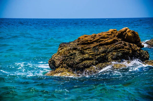 Las olas oceánicas que rompen en las rocas de la costa. — Foto de Stock