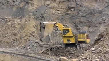 Hidrolik kazıcı BelAZ 'ye kaya yüklüyor.