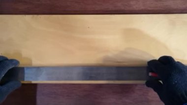 Ahşap bir tahtanın cetveline çizilmiş bir kalemle. Tahtadaki mesafeyi ölçer.