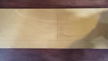 Ahşap bir tahtanın cetveline çizilmiş bir kalemle. Tahtadaki mesafeyi ölçer.