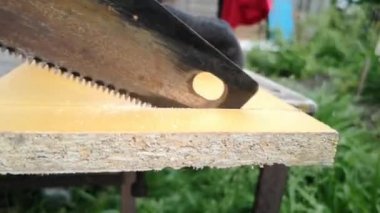 Adam tahta tahtayı testereyle kesiyor..