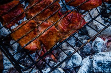 Barbekü ızgarada hazır. Ateşten duman çıkıyor..