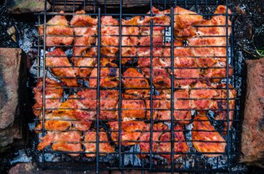Barbekü ızgarada hazır. Ateşten duman çıkıyor..