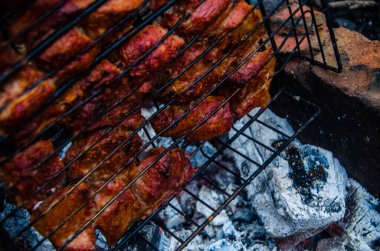 Barbekü ızgarada hazır. Ateşten duman çıkıyor..