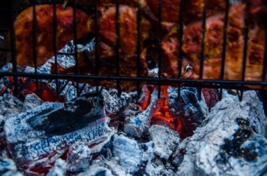 Barbekü ızgarada hazır. Ateşten duman çıkıyor..