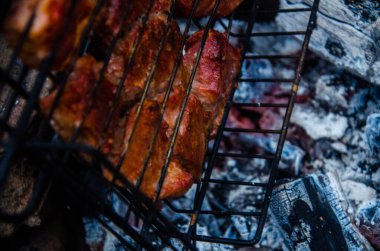 Barbekü ızgarada hazır. Ateşten duman çıkıyor..