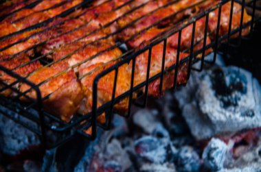 Barbekü ızgarada hazır. Ateşten duman çıkıyor..