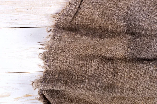 Tahta arka planda çuval bezi.