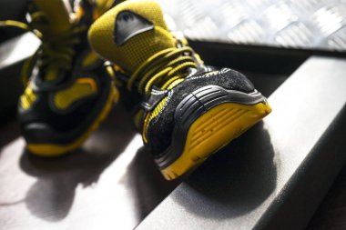 Spor salonunda UNBRANDED modern spor ayakkabı. Siyah-Sarı. Rahat ayakkabılar.