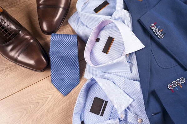 Conjunto de ropa clásica para hombre - traje azul, camisas, zapatos marrones, cinturón y corbata sobre fondo de madera. —  Fotos de Stock