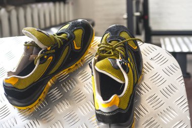 Spor salonunda UNBRANDED modern spor ayakkabı. Siyah-Sarı. Rahat ayakkabılar.