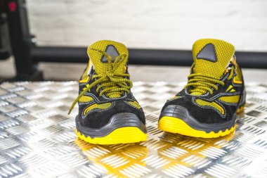 Spor salonunda UNBRANDED modern spor ayakkabı. Siyah-Sarı. Rahat ayakkabılar.