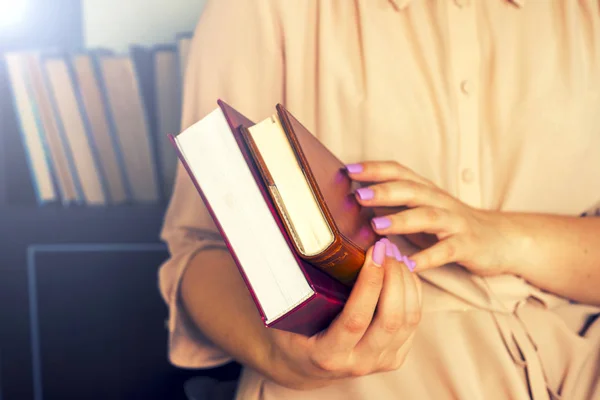 Hafif elbiseli genç kız bir kitap okuyor. Kadın elleri ellerinde bir kitap tutuyor. — Stok fotoğraf