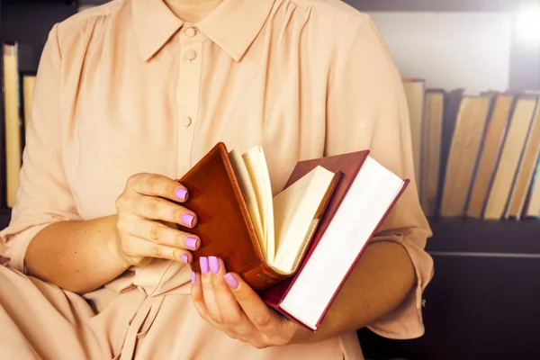 Hafif elbiseli genç kız bir kitap okuyor. Kadın elleri ellerinde bir kitap tutuyor. — Stok fotoğraf