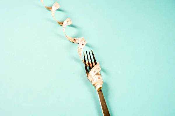 Gabel und Messer mit einem Zentimeter auf blauem Hintergrund, Ernährung, gesunder Lebensstil. — Stockfoto