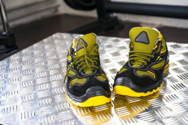 Spor salonunda UNBRANDED modern spor ayakkabı. Siyah-Sarı. Rahat ayakkabılar.