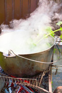 Çorbanın kazıkta çorba kaynar. Yangında bir tencerede çorba.