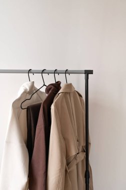 Trençkotlu elbise askılığı ve doğal toprak renginde forma örgü, moda sektöründe markalaşma için boş kopya alanı olan minimal şablon..