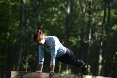 Kız parkta bir spor barına yapıyor