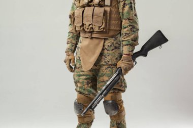Kamuflajlı asker elinde tüfekle
