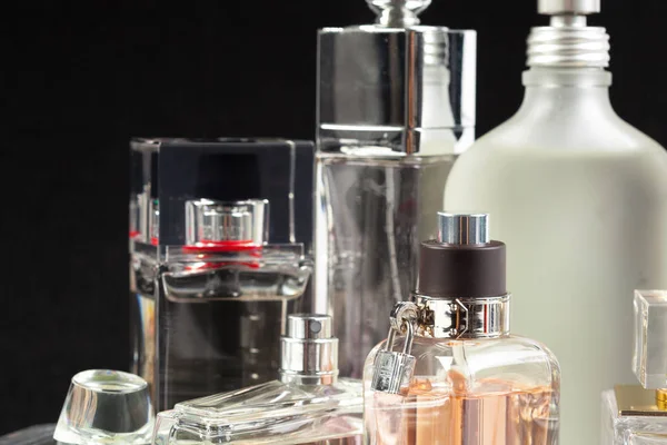 koyu arka plan üzerinde parfüm şişeleri