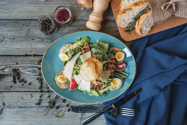 Taze tavuk ve Sezar salatası mavi plaka üzerinde