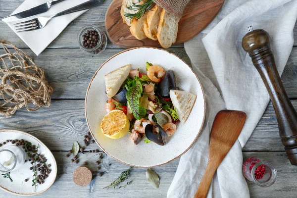 Beyaz tabak içinde deniz ürünleri salatası