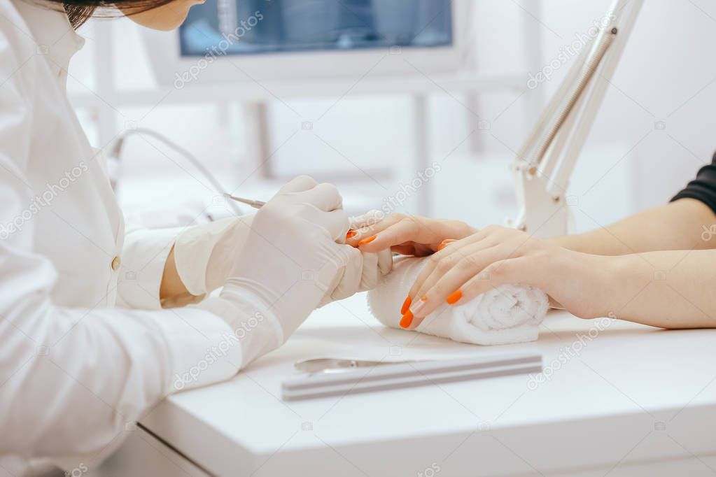 Manicurist doing manicure in salon