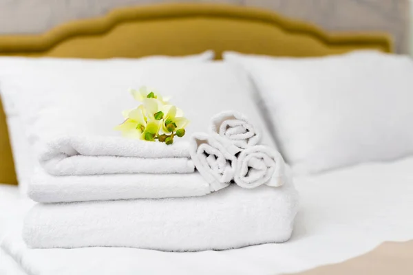 Stack of towels with flower decor in hotel room