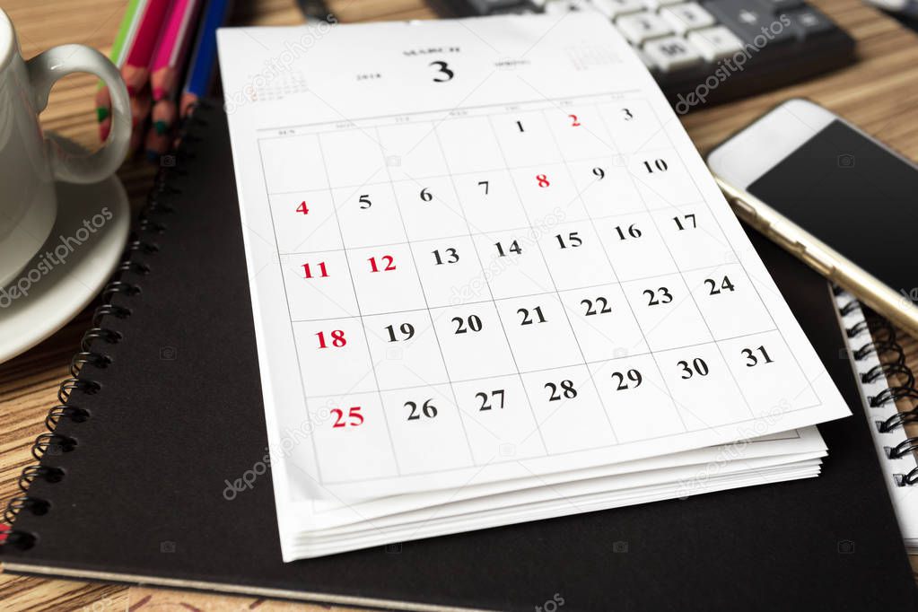work space with calendar pages on wooden background