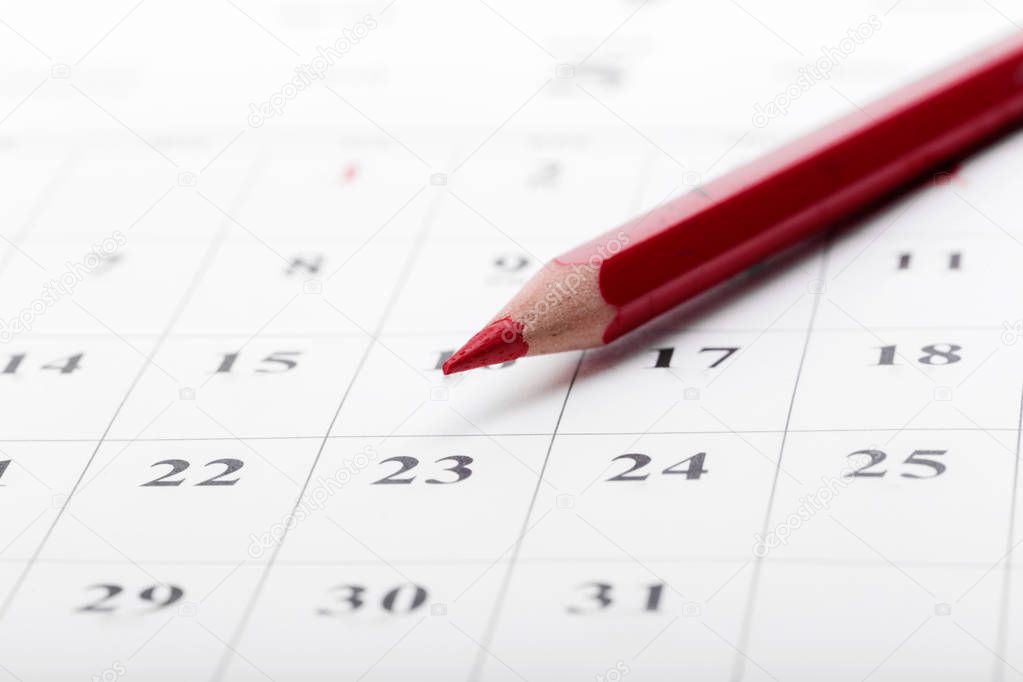 close up of calendar with red pencil 