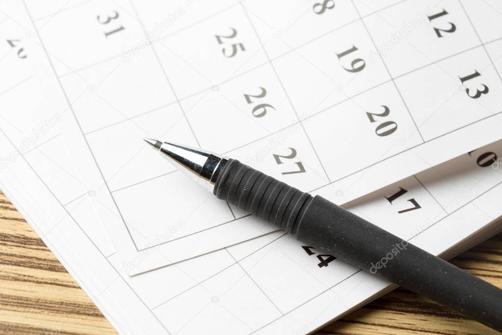 calendar with pen on wooden table