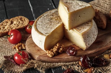 Domates ve ahşap masa üzerinde fındık ile peynir