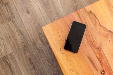 Hareket eden telefon ile boş ekran mockup ahşap masa arka plan üzerinde