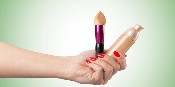 Женская рука с фундаментом косметический инструмент изолирован на цветном фоне
