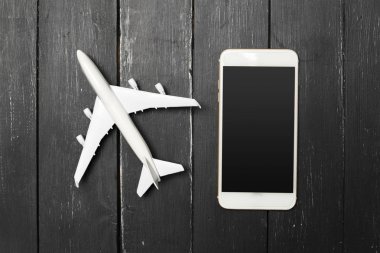 Model uçak ve ahşap arka plan üstünde smartphone