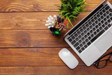 Laptop, defter üzerinde ahşap çalışma masası 