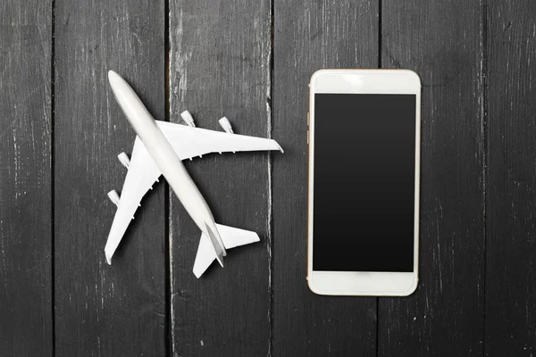 Model uçak ve ahşap arka plan üstünde smartphone