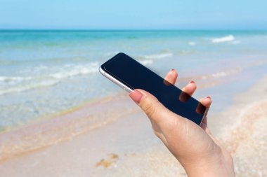 Güzel kadın eli beach adlı akıllı telefon kullanma
