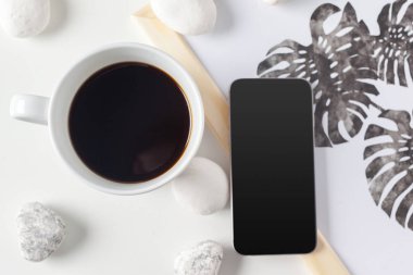 Beyaz arka plan üzerinde izole koku kahve Kupası ile Smartphone ve beyaz fincan yakın çekim 