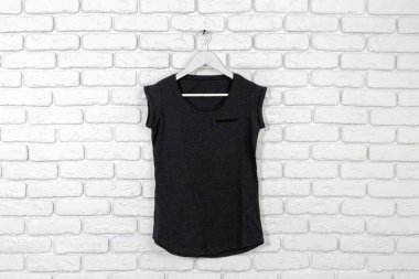t-shirt ile tuğla badanalı duvara askı