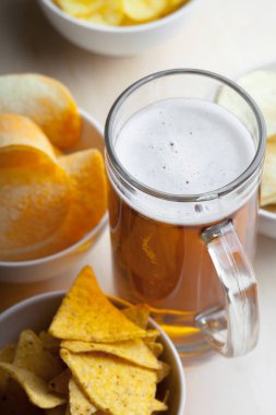 Lager bira cam ve ahşap zemin üzerine patates cipsi