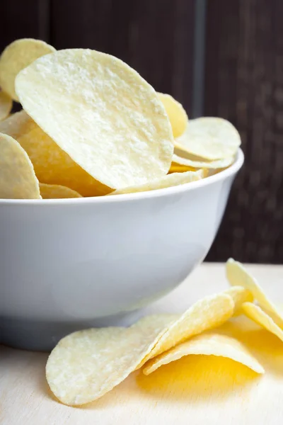 Crispy potato chips in bowl on table