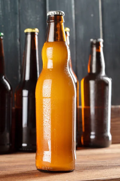 Bottles with beer on wooden background