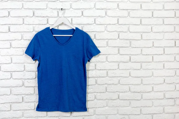 brick whitewashed wall with t-shirt on hanger