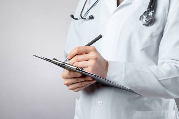 close up of medical doctor hands holding clipboard