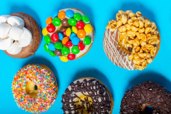 Verschiedene Donuts Auf Blauem Hintergrund — Stockfoto