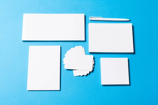 blank office objects organized for company presentation on blue paper background