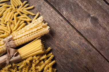 Karışık makarna. Ahşap bir arka plan üzerinde. Üstten görünüm