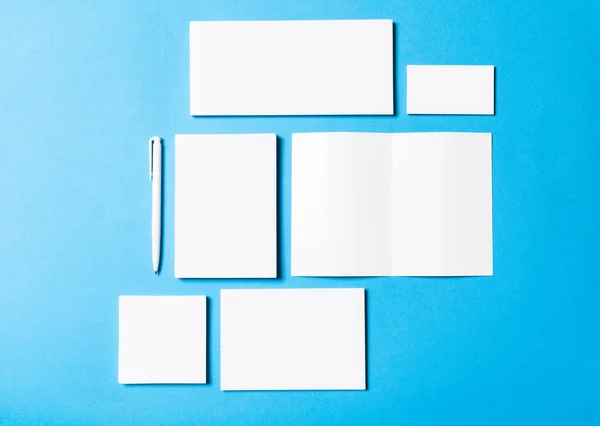 blank office objects organized for company presentation on blue paper background